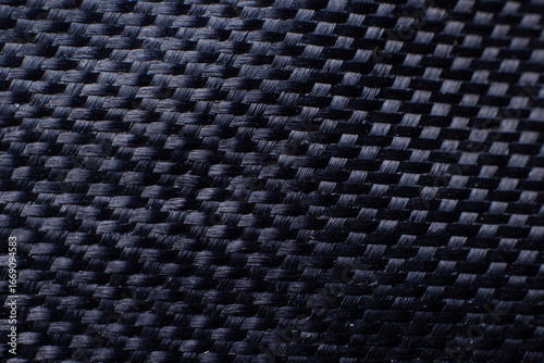 Close up texture of black carbon fiber material, modern woven surface pattern used in automotive, aerospace, industry, and technology design.