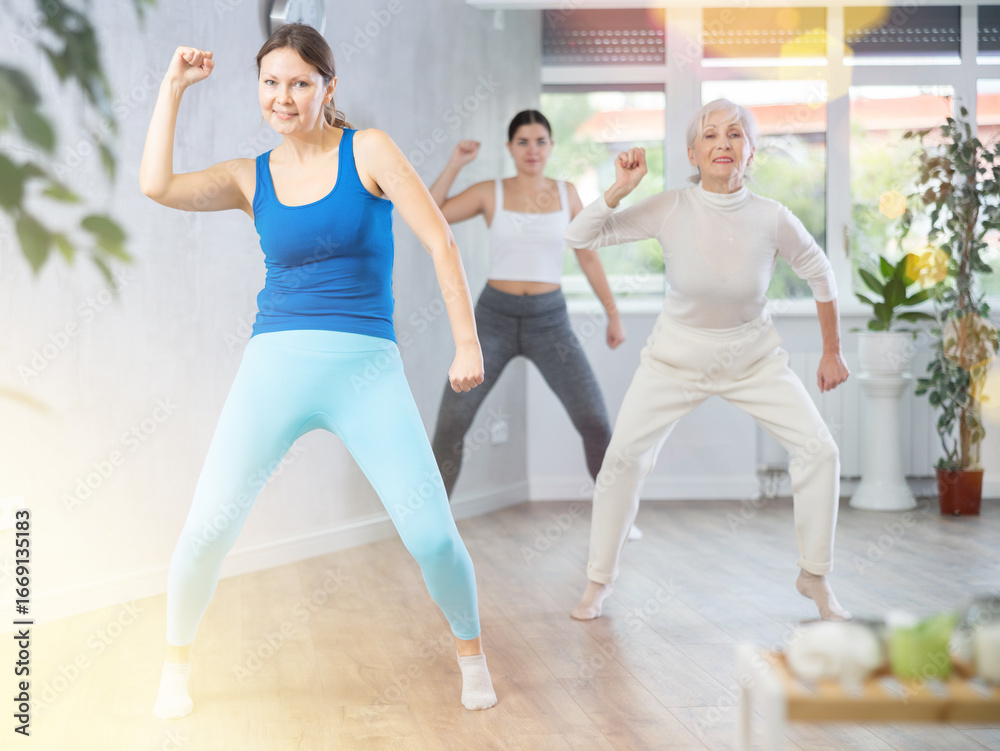 Fototapeta premium Sporty women learning aerobic dances in wellness center