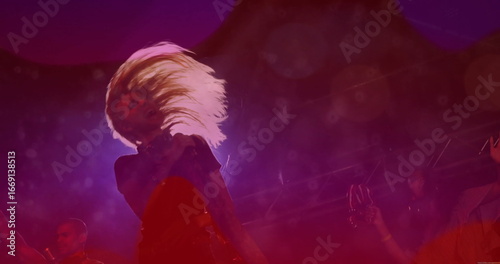 Foto Flipping female performer tossing long blonde hair back on live music stage, wit