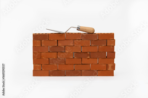 Construction site on a brick wall. Building a miniature tower from bricks. Construction materials and tools