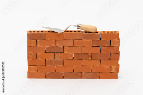 Construction site on a brick wall. Building a miniature tower from bricks. Construction materials and tools