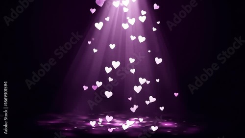 Heart shapes descend in purple light beam on a dark backdrop perfect for romantic events or celebrations conveying love and affection.