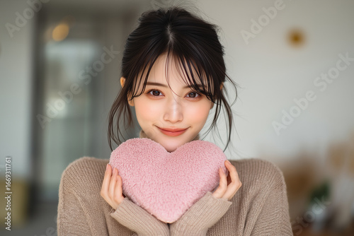 ハート型のオブジェを持つ女性