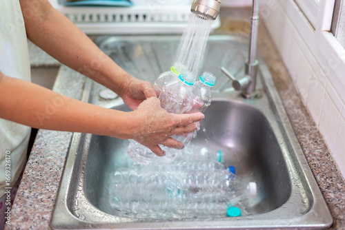 Female hands washing plastic bottle for reuse in kitchen sink, eco-friendly lifestyle and sustainable recycling concept