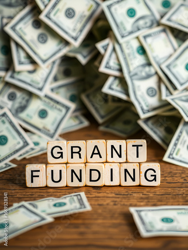 Grant funding symbol. Concept words Grant funding on wooden blocks. Beautiful background from dollar bills. Business and grant funding concept. Copy space.