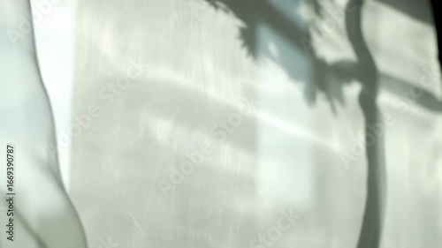 White fabric curtains gently swaying in a soft breeze by an open window on a sunny day