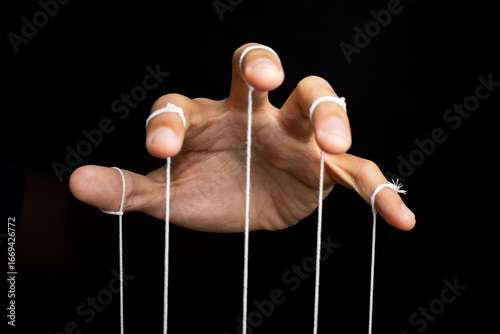 Canvas Print male puppeteer hand with strings isolated on black background