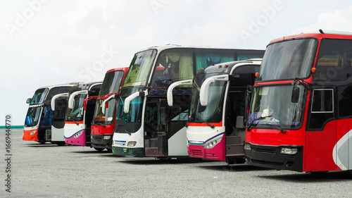 Schilderij op canvas Several buses of different colors are lined up at a transportation hub, ready for passengers