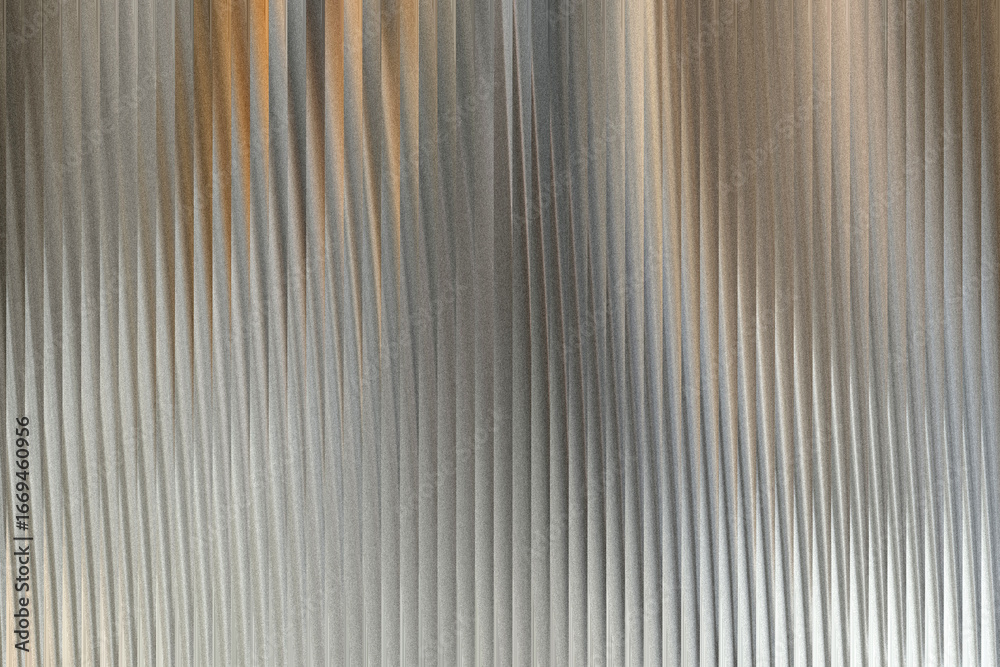Obraz premium A textured metallic surface with vertical ribbed patterns and subtle hints of warm orange light reflecting on the corrugated metal