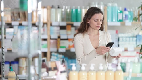 Woman in pharmacy scans QR code on omega 3 supplement. Health care, healthy lifestyle, prevention. Dietary supplements, replenishment of vitamin and microelement deficiencies.
