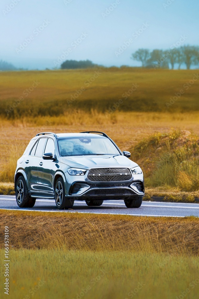 Fototapeta premium Modern crossover SUV driving through green countryside