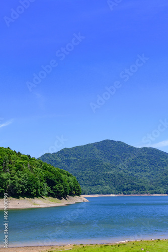 Nukabira River Bridge with Nukabira Lake, River and Dam under July Blue Sky, Hokkaido Japan

