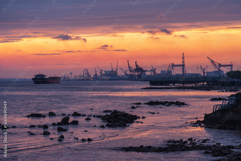 Obraz premium Cargo Ship in the harbour district under Sunset glow