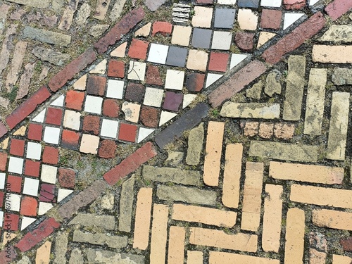 Decorative square and rectangular paving bricks in contrasting colors and lines on a European walkway