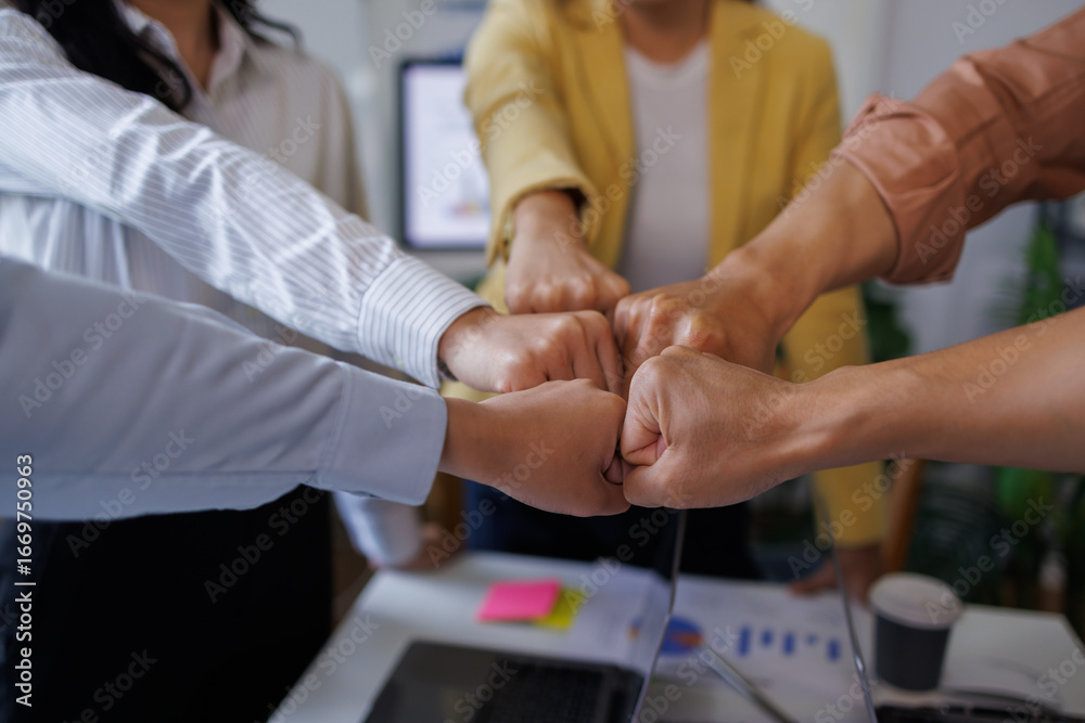 Obraz premium Group of asian workers in the office put their arms together and celebrate success. Success in business, startup, joy at work 
