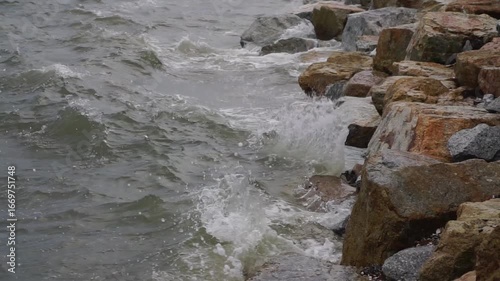Close up shot of sea waves crashing against rock