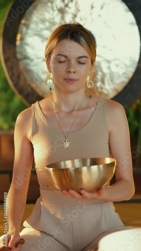 Woman using Tibetan bowl in sound healing session
