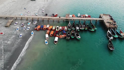 Teknaf, Bangladesh - 20 August 2025: Aerial view of boats docked near a pier, contrasting the sandy beach with the turquoise waters of the Bay of Bengal.