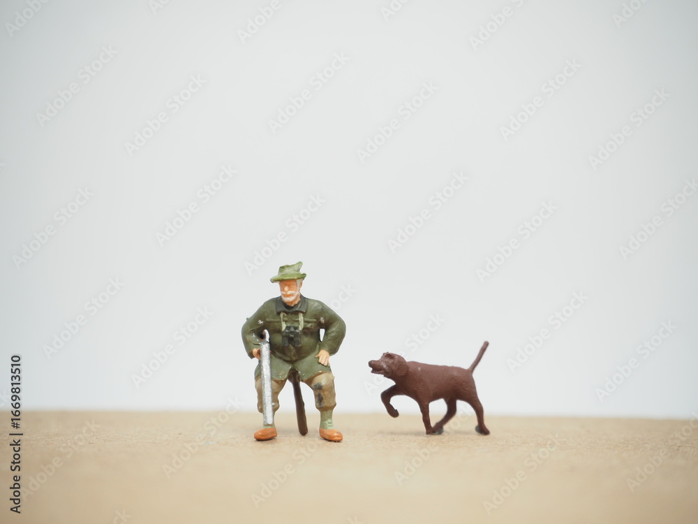 Fototapeta premium Mini toy of action figure at table with blurred background. Toy photography concept. Hunter man at outdoor concept. Adventure and explore people.