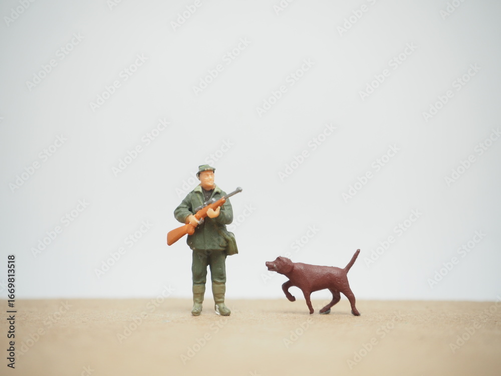 Fototapeta premium Mini toy of action figure at table with blurred background. Toy photography concept. Hunter man at outdoor concept. Adventure and explore people.