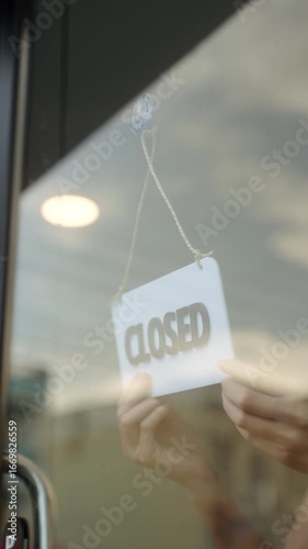 Close-up Happy Owner or waitress in apron turns the sign from closed to open, welcoming customers a new cafe and small business restaurant in morning. New business coffee shop cafe. Vertical video.