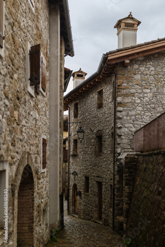 A stone alley in the mountain village of Poffabro, Friuli Venezia Giulia. The old houses and wooden roofs create an authentic and historic atmosphere.