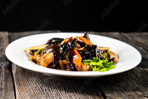 Chinese Mixed Vegetable Stir-Fry with Wood Ear Mushroom Black Fungus on dark background. Asian food. Chinese cuisine. Seafood. Vegetables