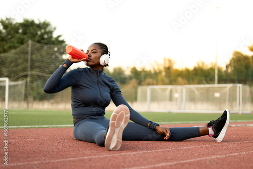 Принти на полотні Black female runner or athlete stretching body and warming up before training