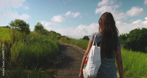 Young woman enjoys a peaceful walk along the campuhan ridge walk, a scenic trail in ubud, bali known for its lush greenery and stunning views