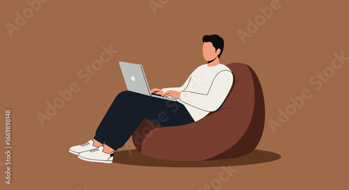 Young man working comfortably on his laptop while sitting in a bean bag chair. Ideal for concepts of remote work, freelance, or relaxed home office environments.