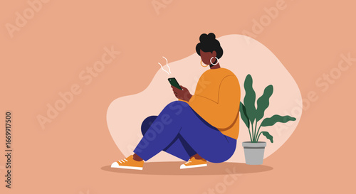 Relaxed young woman with dark skin sits on the floor, actively engaged with her smartphone in a minimalist home setting. Concept of digital communication, social media, and modern lifestyle.