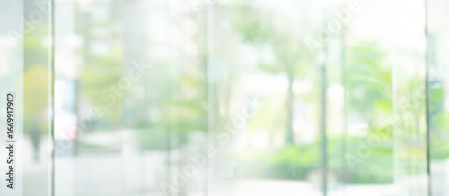 Big window glass building with blur green gaeden.