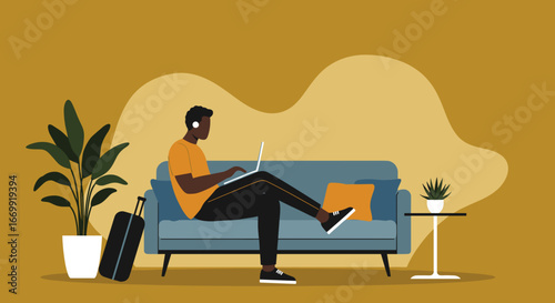 Young man working remotely on a laptop with headphones, sitting on a sofa with luggage, embodying flexible work and travel lifestyle.