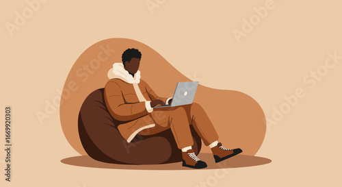 A man works comfortably on his laptop, seated on a bean bag chair in a cozy, relaxed setting. Ideal for remote work, freelance, and modern lifestyle concepts.