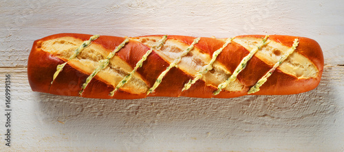  Laugenbaguette mit Kräuterbutter auf weissem Holzfond