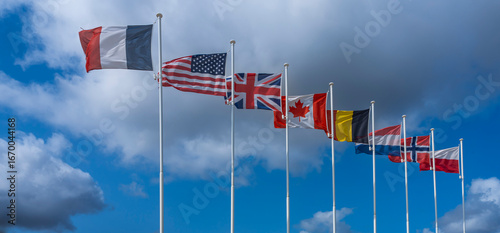 Foto Langrune-Sur-Mer, France - 08 05 2025: Alignment of national flags of the Allies
