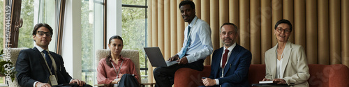 Header of diverse group of middle aged professionals sitting together in modern office, Black man holding laptop while Caucasian man, woman, and colleagues engaging in business meeting Free Download Header of diverse group of middle aged professionals sitting together in modern office, Black man holding laptop while Caucasian man, woman, and colleagues engaging in business meeting - GFXLoad