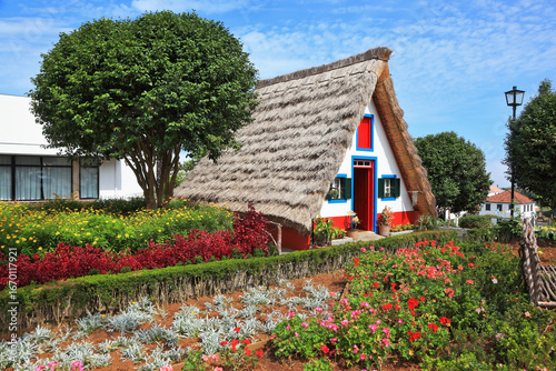 Fototapeta Charming white cottage with a thatched roof gable