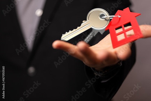 Obraz na plátně Image of a real estate agent offering house keys, symbolizing homeownership and new beginnings
