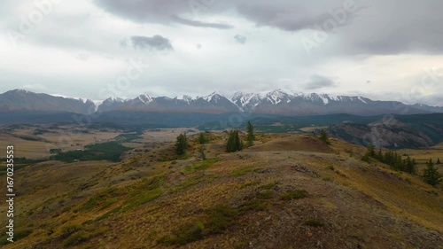 Drone shot of Belukha Mountain in Altai, Russia. Stunning snow-covered peaks above green valleys and rolling hills. Perfect for adventure, travel, and nature stock video.