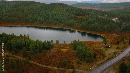 Aerial drone view of Kidelu Lake in Altai Republic, Russia. Scenic mountain lake surrounded by forest and autumn colors, perfect for travel, tourism, and nature footage.