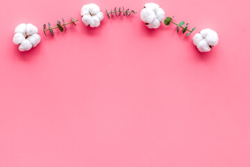 Flowers border with eucalyptus branches and dry cotton on pink background top view space for text. Blog mockup
