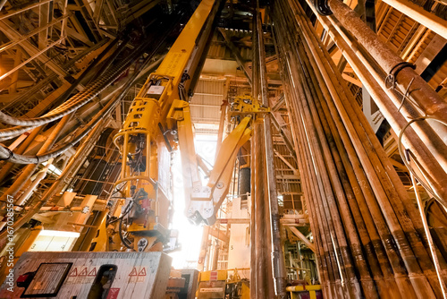 drilling equipment inside drilling rig on an offshore oil platform. hook, swivel and drill pipes and more