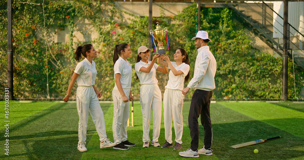 Fototapeta premium Indian asian young adult gen z sports woman lady group team standing with coach man win cricket match trophy do celebrate outdoor male trainer female player cheering having fun joy outside play ground