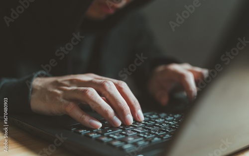 Foto Hacker hands typing on laptop keyboard in dark environment