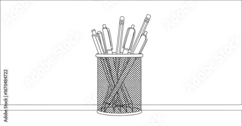 Metal mesh pen holder filled with pens and pencils sits on a white surface