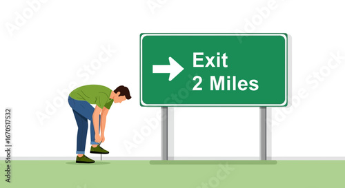 Man Tying Shoe Near Exit Sign On Side Of A Green Roadway