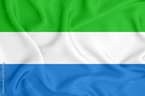 flag of the Republic of Sierra Leone with three horizontal stripes on satin fabric with folds and shadows