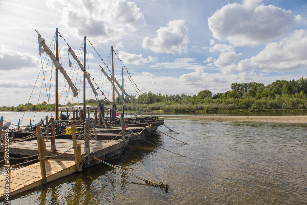 Fototapeta premium bateau traditionnel sur la Loire en été en France à Chaumont-sur -Loire. Toue cabanée, bateau ancien en bois. Paysage, fleuve français sauvage