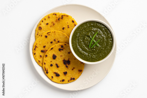 Top view of sarson ka saag with makki ki roti in plate on white background stock photo